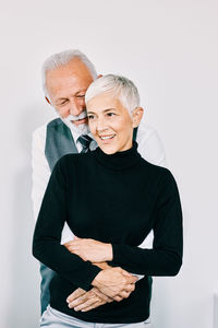 Man and woman standing against white background