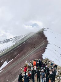 People on mountain against sky