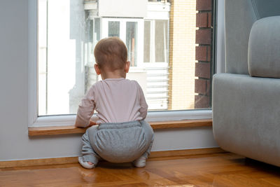 Side view of woman sitting on sofa at home