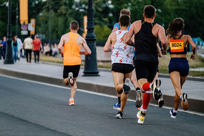 Rear view of people walking on road