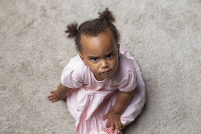 Mixed race baby girl looking up intensely