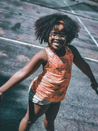 Portrait of smiling girl standing on court during sunny day