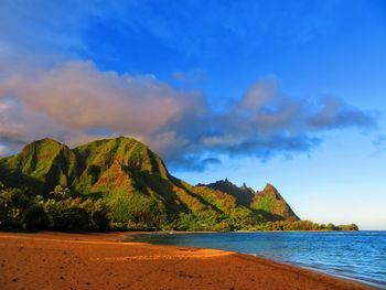 Scenic view of sea and mountains against blue sky