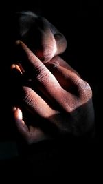 Close-up of human hand against black background