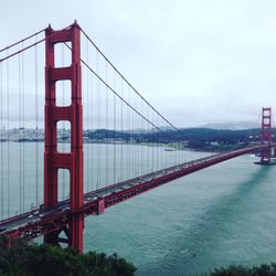 Golden gate bridge over river against sky in city