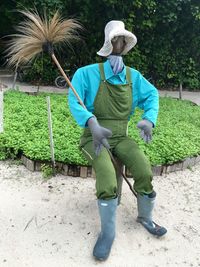 Scarecrow on field against trees