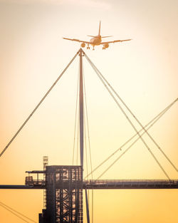 Low angle view of crane against sky during sunset