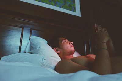 Young woman lying on bed at home