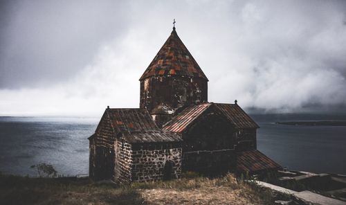 Low angle view of building by sea against sky