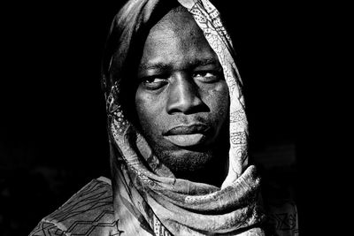 Close-up portrait of young man against black background