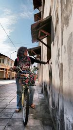 Woman riding bicycle on road in city