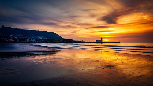 Scenic view of beach against sky during sunset