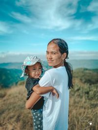 Happy boy standing on land against sky