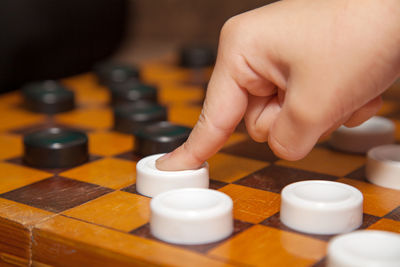 Cropped hand of woman playing board game