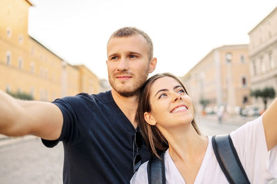 Portrait of smiling couple standing against building