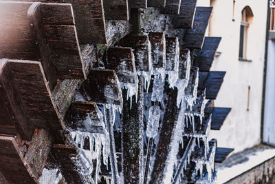 Close-up of icicles against building during winter