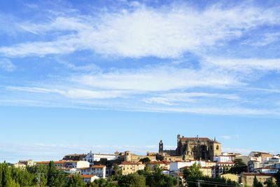 Buildings in city against blue sky