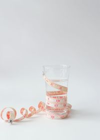 Close-up of drink glass on table against white background