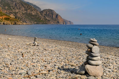 Stack of pebbles on beach against clear sky