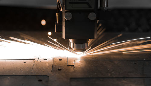 Low angle view of illuminated industry in factory