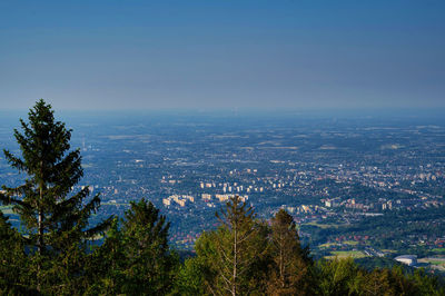 High angle view of city buildings against blue sky