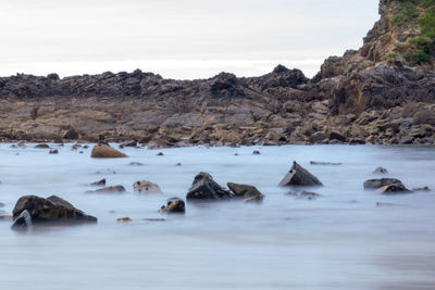 Rocks in sea against sky