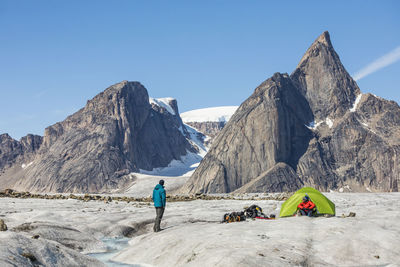 Rear view of people on rock against sky