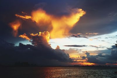 Scenic view of sea against dramatic sky during sunset