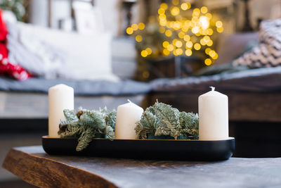 White candles and pine branches in christmas home decor