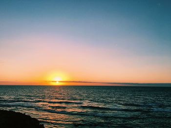 Scenic view of sea against clear sky during sunset