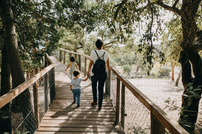 Rear view of people walking on footbridge