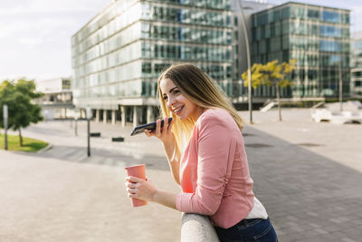 Young woman using mobile phone in city