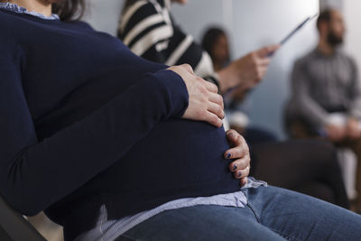 Midsection of pregnant woman in office