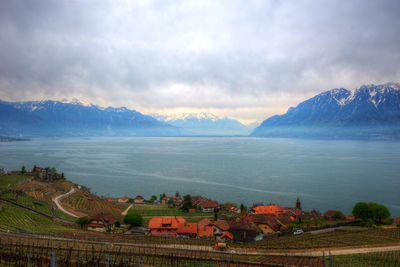 Scenic view of farm and mountains against sky