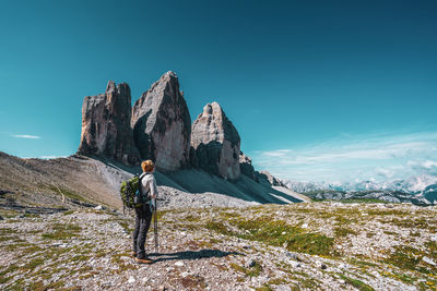 Backpacker on hiking trails in the dolomites, italy. view of the three peaks.