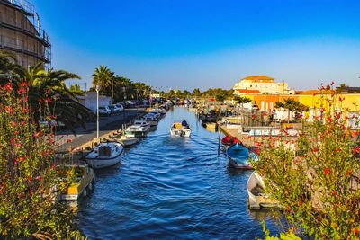 Boats in canal along buildings