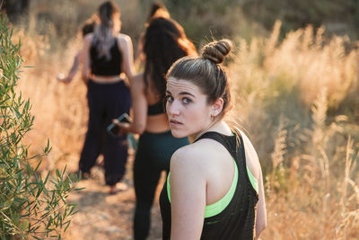 Portrait of young woman standing on field