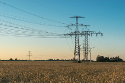 Electricity pylon on field against sky