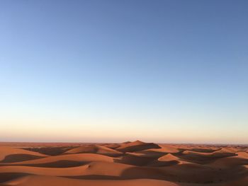 Scenic view of desert against clear blue sky