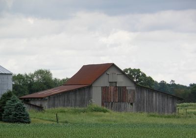 Barn on field against sky