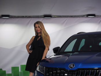 Young woman standing in car