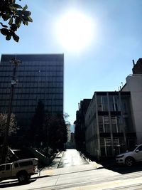 Street amidst buildings against sky on sunny day