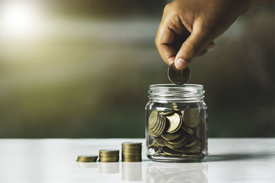 Close-up of hand holding glass jar on table