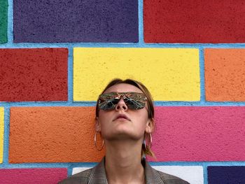 Portrait of young woman against wall