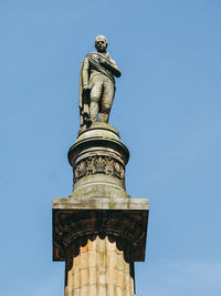 Low angle view of statue of liberty against blue sky