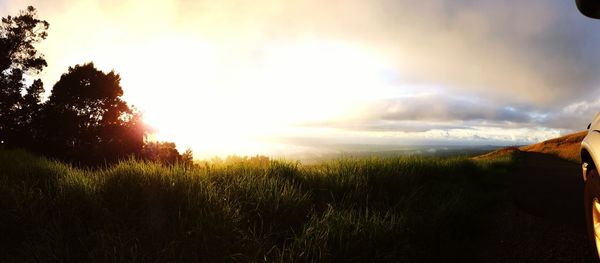 Scenic view of grassy field against cloudy sky