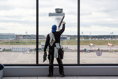 Men standing on airport runway against sky