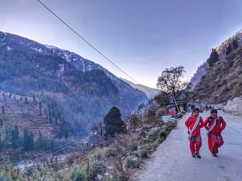 Rear view of people walking on snow covered mountain