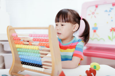 Young girl learn counting by using abacus for homeschooling