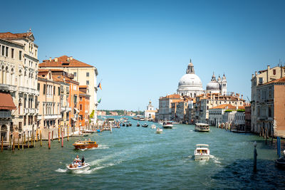 Scenic canal with old buildings in venice, italy. boats and gondolas as the mean of transportation